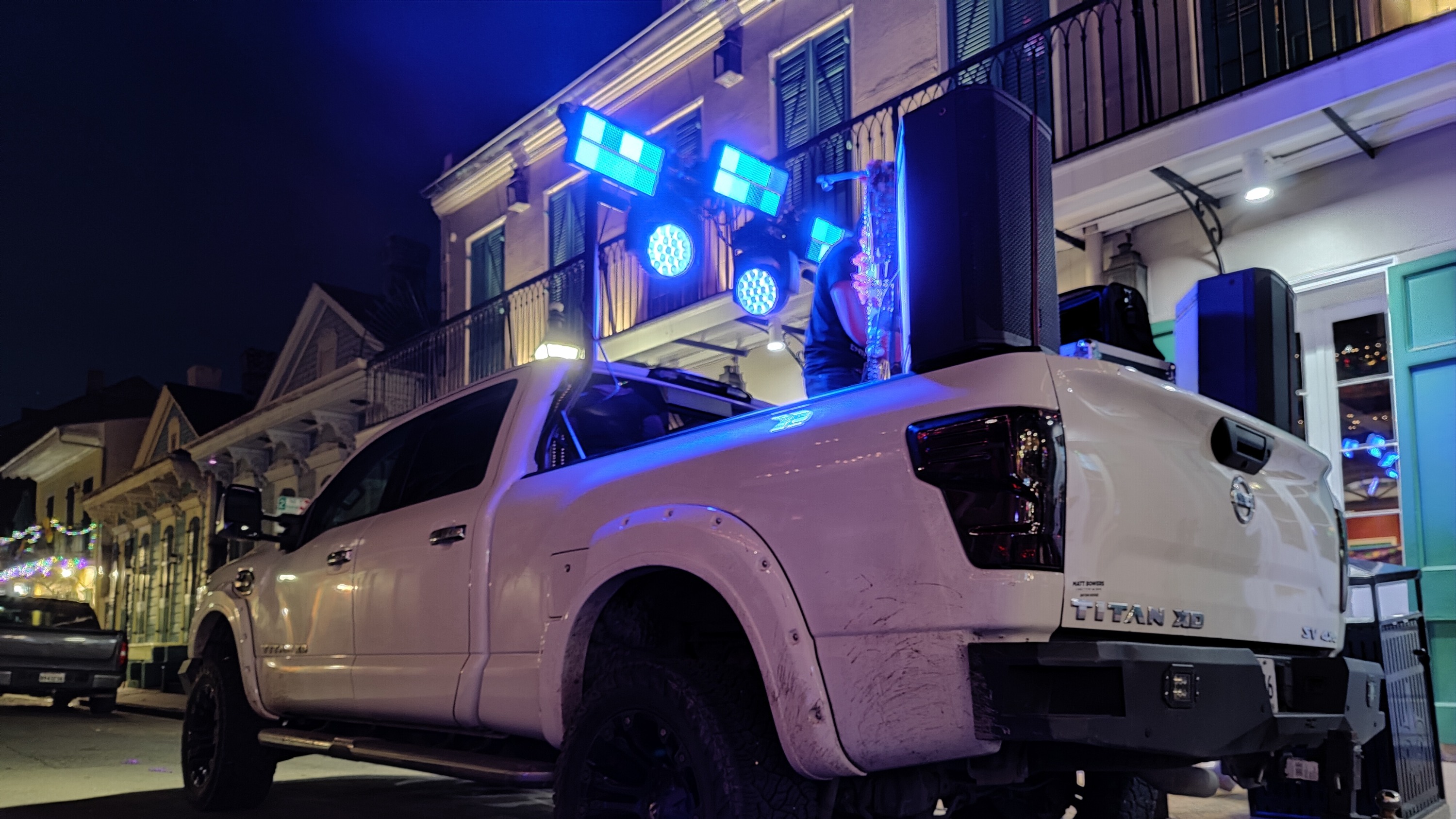 Music and Lights sound truck lit up with stage lights on a French Quarter street at night